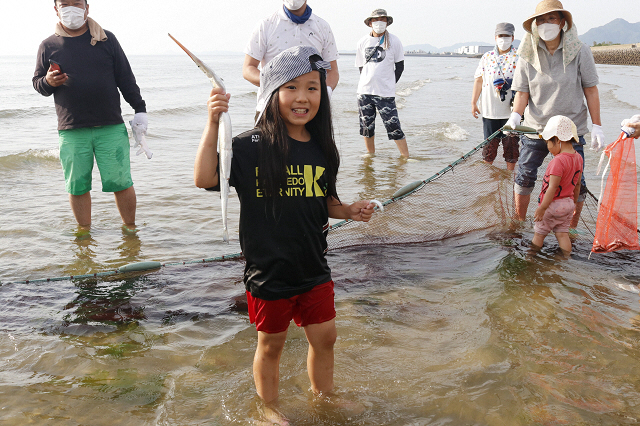 細長い魚を手づかみする女の子