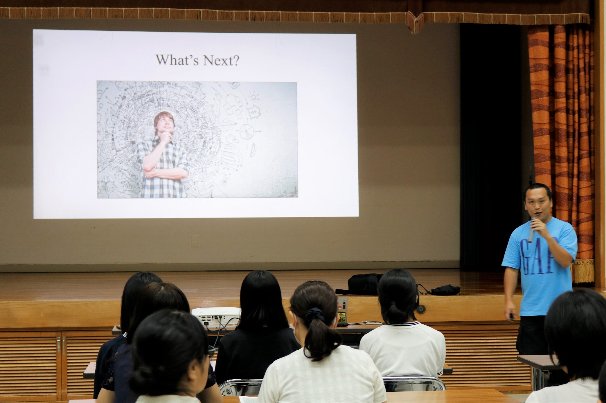 観音寺市国際交流協会の高嶋副会長が学生たちに呼びかける様子