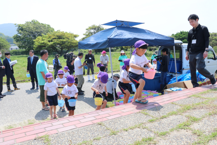慎重にバケツを運ぶ園児