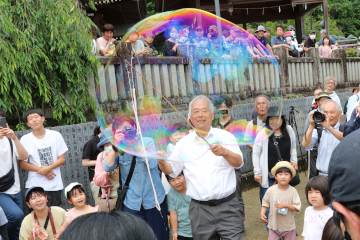 観客に囲まれてパフォーマンスをするシャボン玉おじさん