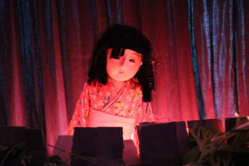 不気味な色に照らされた日本人形のおばけ