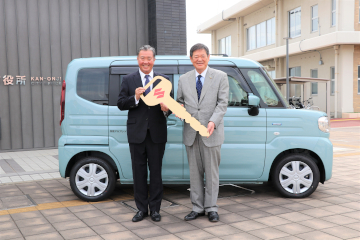 寄贈された福祉車両の前で、ゴールドキーを持つ清下洋介代表取締役社長と佐伯市長