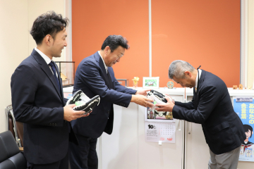 野球用具を受け取る十河教育長