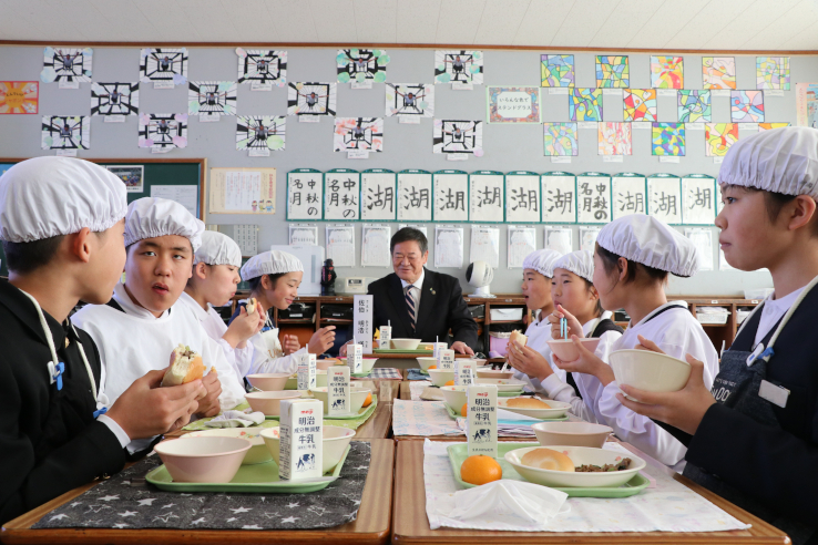 一緒に給食を食べる児童と佐伯市長