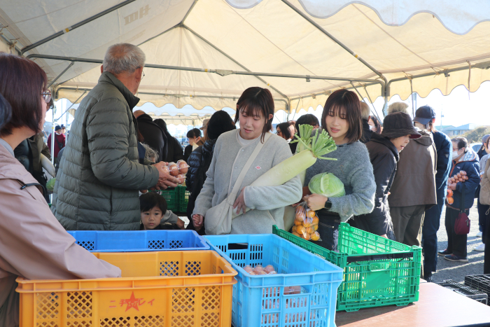 新鮮な野菜を手にする来場者
