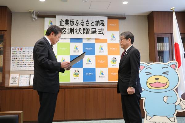 感謝状を読み上げる佐伯市長と、米田理事長