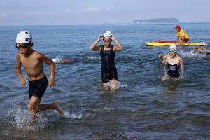 キッズトライアスロン大会で海で泳でいる写真